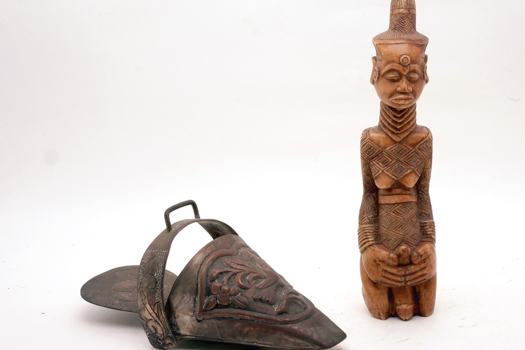 Carved Tribal Statue and Ornate Metal Stirrup