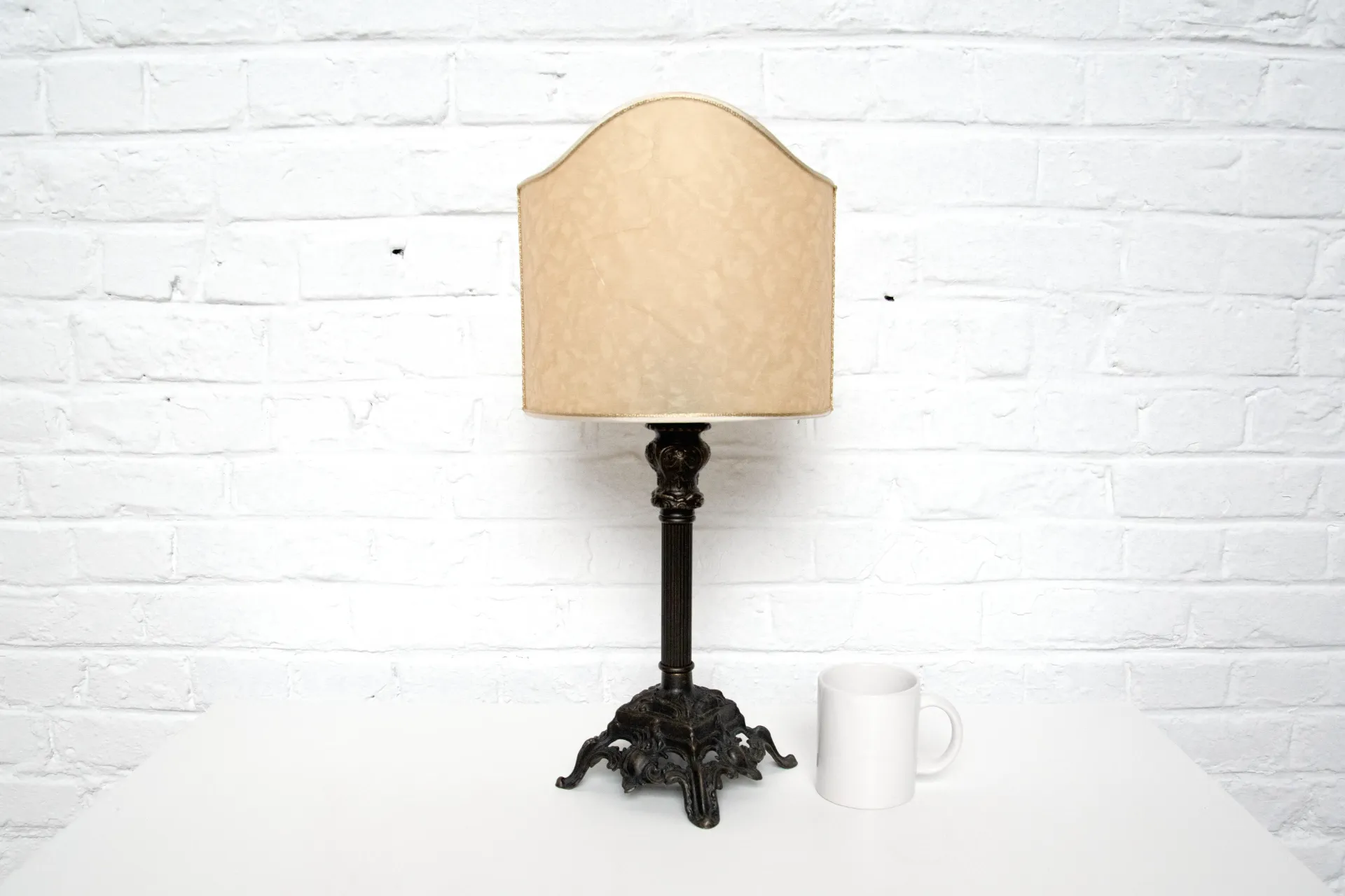 Antique Bronze Table Lamp with Beige Shade and White Mug.