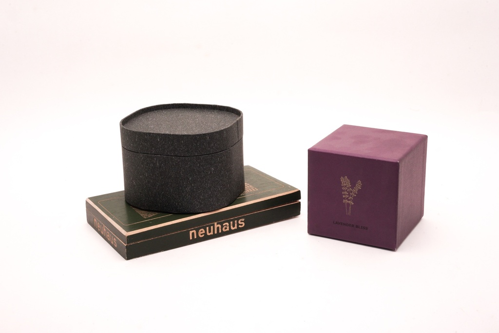 Elegant Packaging Trio: Black Cylindrical Box, Neuhaus Chocolate, and Lavender Bliss Cube